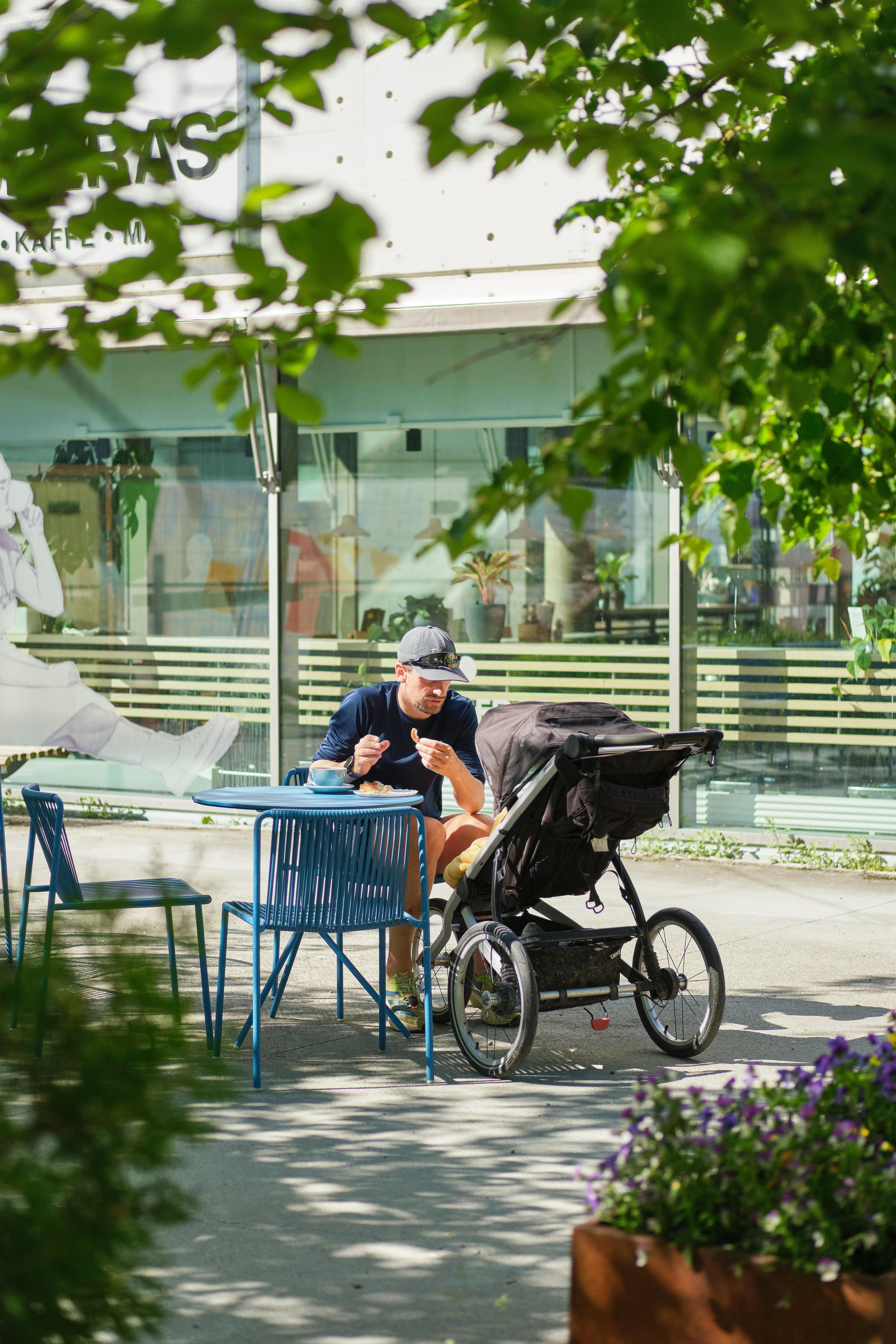 Bilde av mann som sitter på uteserveringen på Slabberas i Teknobyen, med barnevogn